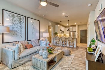 a living room with a couch and a coffee table in front of a kitchen at The Beck at Hidden River, Tampa, FL, Florida